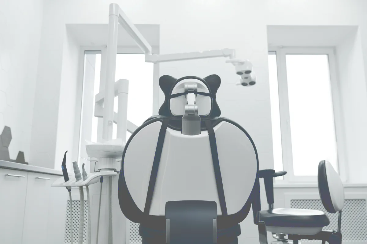 A modern dental surgery with the chair and equipment in daylight.